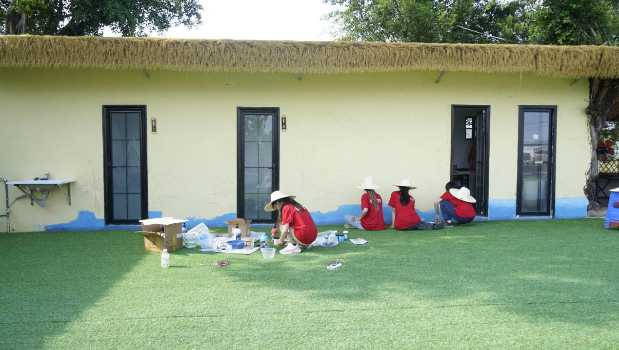 圖為實(shí)踐隊(duì)隊(duì)員繪制墻繪過程