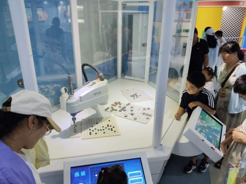 圖為游客與下棋機(jī)器人互動